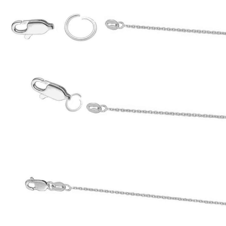 Puede incluir: Primer plano de cierres de joyer&iacute;a plateados, anillas y segmentos de cadena. Los cierres son de estilo pinza de langosta y las cadenas son delicadas. Los componentes se muestran sobre un fondo blanco, mostrando los detalles de los hallazgos de joyer&iacute;a.