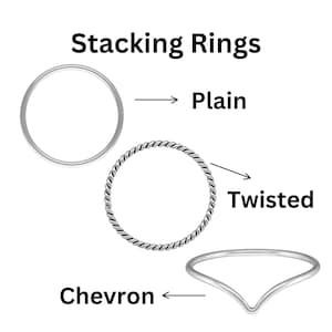 Könnte beinhalten: Drei silberne Stapelringe. Der erste Ring ist schlicht, der zweite Ring ist gedreht und der dritte Ring ist chevronförmig.