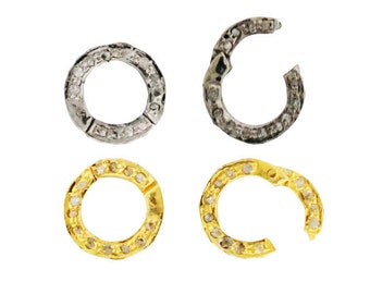 May include: Four silver and gold jump rings with a circle of small diamonds around the outside. The rings are open and ready to be used for jewelry making.