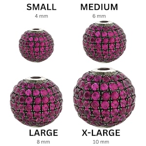 May include: Four spherical beads in varying sizes, from small (4 mm) to X-Large (10 mm). Each bead is covered in small, magenta-colored stones. The word "SMALL" is above the 4 mm bead, "MEDIUM" above the 6 mm bead, "LARGE" above the 8 mm bead, and "X-LARGE" above the 10 mm bead. The word "ONE" is in a black circle.