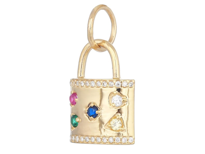 May include: A gold padlock charm featuring a row of small clear stones along the top and bottom edges. The front surface is decorated with five larger, multi-colored inset stones in red, blue, green, white, and yellow, and a gold jump ring.