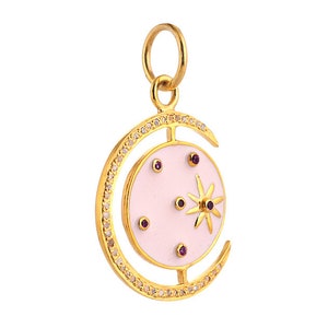 May include: A gold charm pendant featuring a pink enamel crescent moon with a star and small purple gemstones. The charm is surrounded by a circle of small clear gemstones.