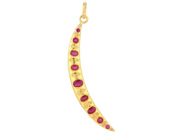 May include: A gold crescent moon pendant with red and white gemstones. The pendant is a delicate and elegant piece of jewelry.