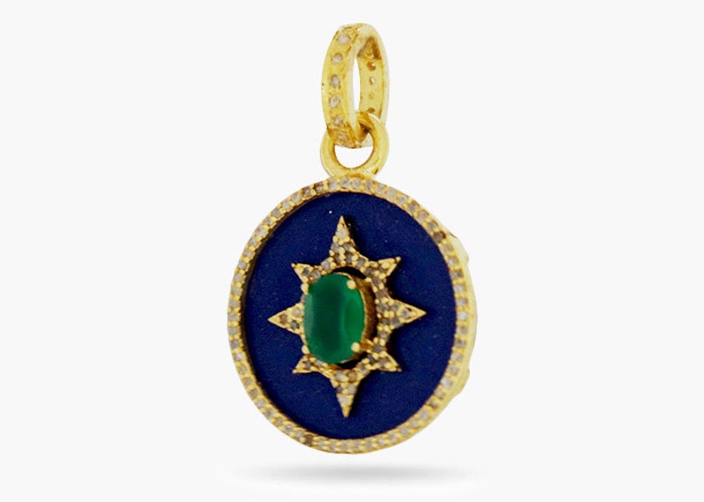 K&ouml;nnte beinhalten: Ein goldener Anh&auml;nger mit einem blauen Emaille-Kreis und einem gr&uuml;nen Edelstein in der Mitte. Der Kreis ist von einem goldenen Sternburst-Design mit kleinen wei&szlig;en Edelsteinen umgeben.