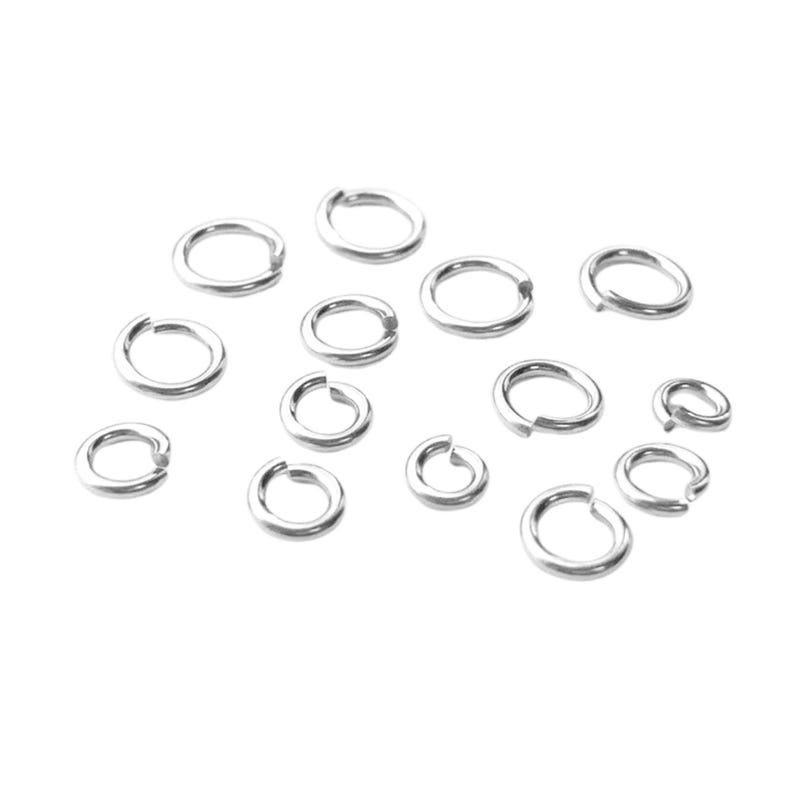 May include: A collection of silver-colored jump rings of various sizes, scattered against a white background. The rings are open, ready for use in jewelry making or other crafts. The metal has a shiny, reflective surface.