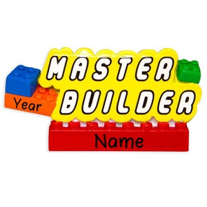 May include: Yellow and red Lego-themed ornament with the words "Master Builder" and spaces for a name and year.