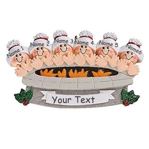 May include: A personalized Christmas ornament featuring six people gathered around a campfire. The ornament is white with red and gold accents. The text "Your Text" is printed on the ornament.