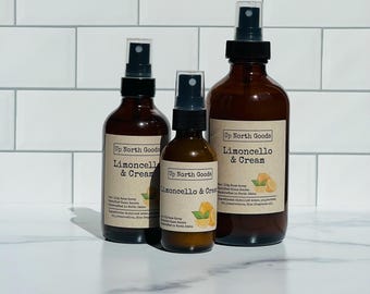 May include: Three brown glass spray bottles of varying sizes, labeled "Limoncello & Cream" with a lemon graphic. The bottles have black spray nozzles and white labels. The brand name "Up North Goods" is also visible.