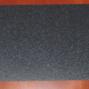 May include: A black mouse pad with a textured surface.