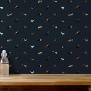 May include: A dark blue wallpaper with a repeating pattern of white, brown, and black chickens. The wallpaper is shown on a wooden surface.