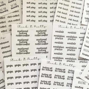 May include: Several white sticker sheets with black text. Phrases include "Do the laundry," "Soft play," "Emotional fucking rollercoaster," "Meditate," "Yoga," and "Feeling all the feelings." The stickers are for planning.