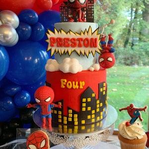 Puede incluir: Un pastel de cumplea&ntilde;os de dos pisos rojo y azul decorado con un tema de Spiderman. El pastel est&aacute; decorado con un personaje de Spiderman, un paisaje urbano y las palabras "Preston" y "Four".