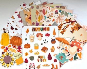 May include: A set of autumn-themed stickers and patterned papers. The stickers feature fall-themed illustrations like mushrooms, leaves, pumpkins, acorns, and a teapot. The papers have various autumnal patterns with leaves, acorns, and other fall motifs. The text "AUTUMN" and "FALL VIBES" is featured on the stickers.