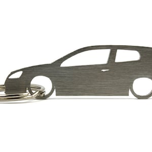 May include: A silver metal keychain shaped like a Volkswagen Golf hatchback. The keychain has a brushed metal finish and a silver key ring.