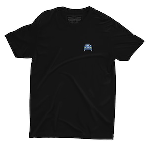 Może przedstawiać: Czarny T-shirt z małym niebieskim i białym nadrukiem samochodu z przodu. Samochód ma żółte reflektory i czerwone światło na górze.