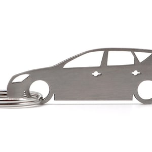 Peut inclure: Un porte-clés en métal argenté en forme de voiture. Le porte-clés est un profil latéral d'une voiture break avec un anneau de clé attaché.