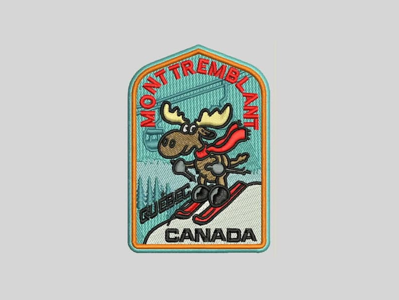 K&ouml;nnte beinhalten: Ein blauer und orangefarbener gestickter Aufn&auml;her mit einem Cartoon-Elch, der einen Berg hinunterski f&auml;hrt. Der Aufn&auml;her tr&auml;gt die Aufschrift "Mont Tremblant" und "Quebec, Kanada".