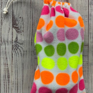 May include: A white drawstring bag with a polka dot pattern. The dots are in shades of pink, green, yellow, and orange.