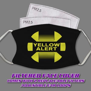 May include: Black face mask with a yellow "YELLOW ALERT" symbol and two replaceable PM2.5 filters. The mask has adjustable ear loops.