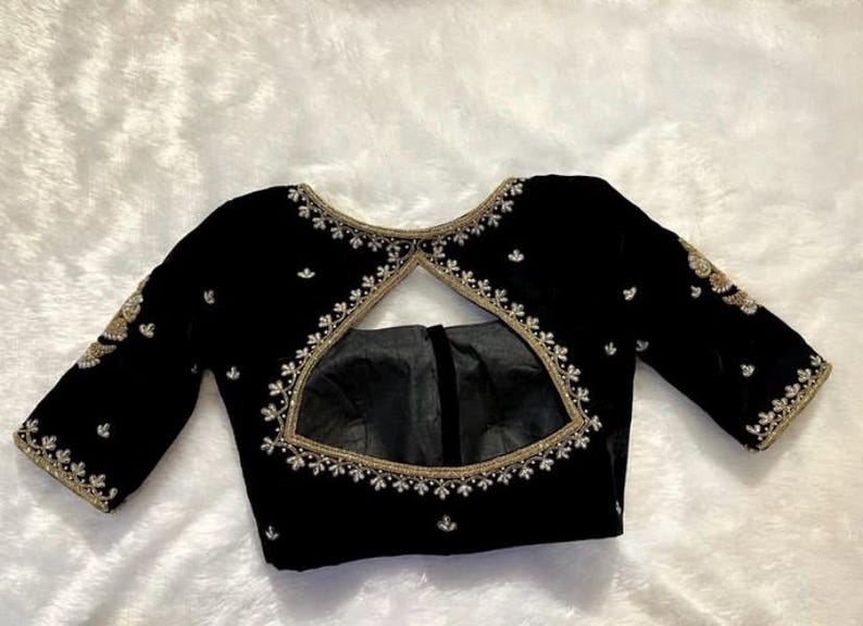 May include: A black velvet blouse with a keyhole back and gold and white embroidery.
