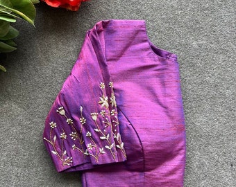 May include: A purple silk blouse with embroidered floral details on the sleeves.