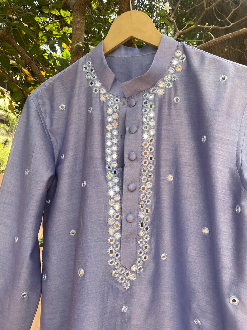 K&ouml;nnte beinhalten: Eine hellblaue Kurta mit einem silbernen Spiegel-Design. Die Kurta hat einen Mandarinkragen und einen Knopfverschluss.
