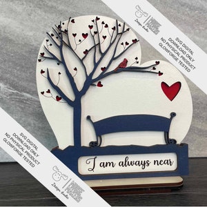 May include: A wooden heart-shaped cutout with a tree, a bench, and a cardinal. The tree has red hearts on the branches. The bench is blue. The heart has a red heart cutout in the center. The text "I am always near" is on a blue plaque at the bottom of the heart.