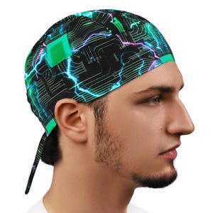 May include: A black head wrap with a circuit board design, neon green and blue lightning bolts. The head wrap has a green border and ties at the back. The design is a repeating pattern.