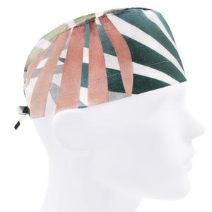 May include: A white, green, and pink patterned surgical scrub hat with a tie on the side.