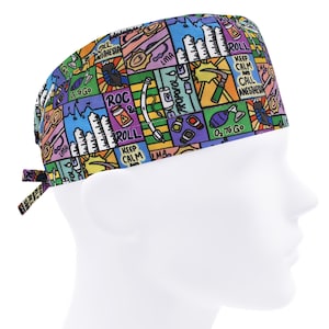 Op de afbeelding: Een kleurrijke chirurgische scrub cap met een herhaald patroon van medische illustraties en tekst. Het ontwerp bevat afbeeldingen van medische instrumenten, gebouwen en zinnen als "Keep Calm and Call Anesthesia". De cap heeft een striksluiting.