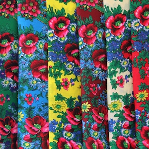 以下が含まれることがあります： 花柄のカラフルな生地のサンプル集。生地には、赤、青、緑、黄、白の花がさまざまな背景に描かれています。