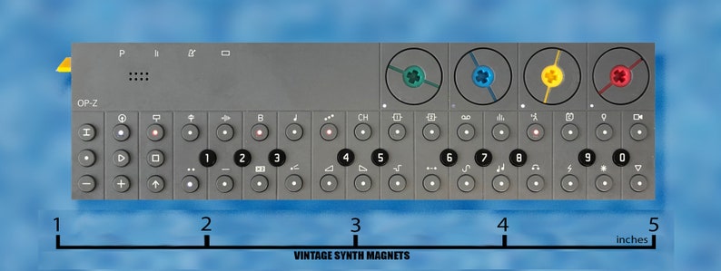 Puede incluir: Un sintetizador gris con el texto "OP-Z" en la parte delantera. El sintetizador tiene una serie de botones y perillas, incluida una fila de botones numerados del 1 al 9. El sintetizador tiene 12,7 cm de ancho.
