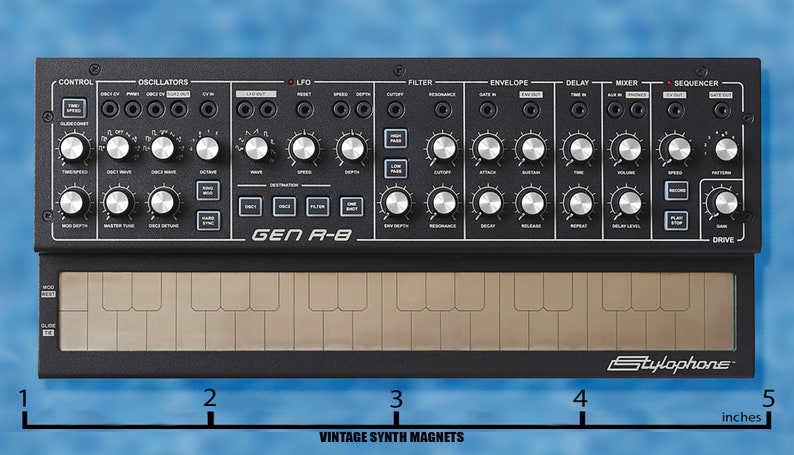 Puede incluir: Un sintetizador negro Stylophone Gen R-8 con un teclado de 25 teclas y una variedad de botones y perillas. El sintetizador tiene 12,7 cm de ancho.