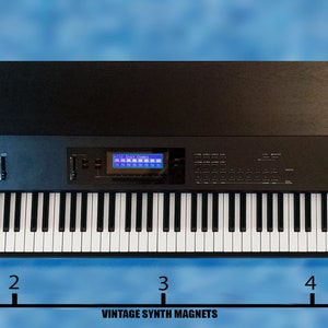 Peut inclure: Un synth&eacute;tiseur noir avec un dessus en bois et un clavier de 61 touches. Le synth&eacute;tiseur poss&egrave;de un &eacute;cran LCD bleu et une vari&eacute;t&eacute; de boutons et de molettes. Le synth&eacute;tiseur mesure 12,1 cm de large.