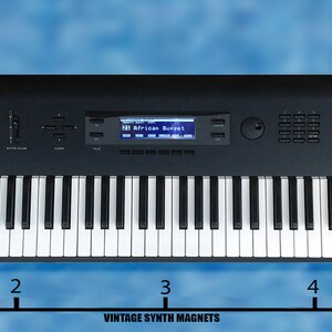 Peut inclure: Un synth&eacute;tiseur Korg MS2000B noir avec un clavier de 61 touches, un &eacute;cran num&eacute;rique affichant "African Sunset" et un panneau de commande avec des boutons et des molettes. Le synth&eacute;tiseur mesure 10 cm de large.