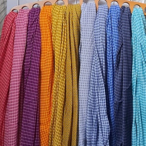 May include: A collection of ten fabric swatches with a geometric pattern. The swatches are arranged in a rainbow color order, starting with red and ending with turquoise.