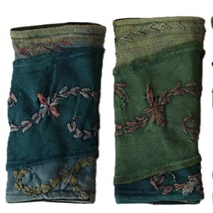 Puede incluir: Cuatro pares de calentadores de muñeca bordados de colores. Cada par está hecho de diferentes tonos de verde, azul y morado con intrincados bordados florales.