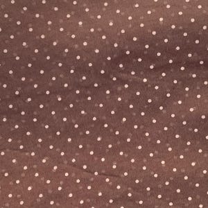 May include: A brown fabric featuring a repeating pattern of small, evenly spaced white polka dots. The material has a slightly sheer, lightweight texture with a consistent grid-like arrangement of the circular white spots across the surface.