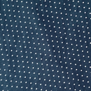 May include: A dark blue fabric featuring a repeating pattern of small, white, circular polka dots distributed evenly across the entire surface. The material has a visible, slightly textured weave, creating a consistent and uniform appearance.