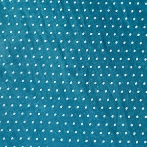 May include: A teal fabric featuring a repeating pattern of small, white, evenly spaced polka dots. The material has a slightly textured surface with a consistent weave, displaying a uniform distribution of the white dots across the blue background.