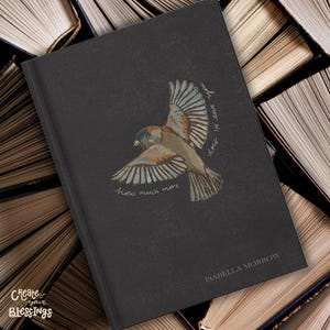 May include: A black hardback book featuring a central illustration of a bird in flight with spread wings. The text "how much more does He love you" is printed in a cursive font around the bird, and "ISABELLA MORROW" appears at the bottom.