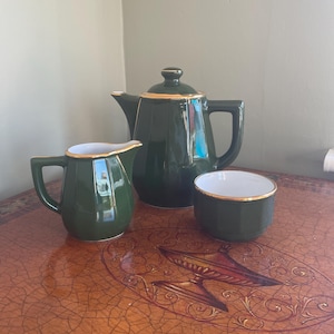 May include: A set of three white ceramic vases with a ribbed texture. The tallest vase is about 25 cm high, the middle one is 20 cm, and the smallest is 15 cm. The vases are of varying heights.