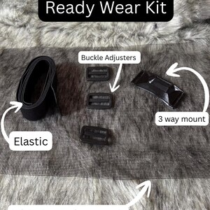 Może przedstawiać: Zestaw Ready Wear zawiera czarną gumkę, regulatory klamry, mocowanie 3-drożne i pełny arkusz siatki na oczy. Tekst "Ready Wear Kit" jest wyświetlany w czarnym prostokącie. Elementy są ułożone na szarej siatce.