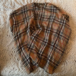 May include: A brown and black plaid shirt with a button-up collar and long sleeves.