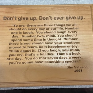 May include: A wooden plaque with a motivational quote by Jim Valvano, "Don't give up. Don't ever give up." The quote is about the importance of laughter, thinking, and experiencing emotions. The plaque is a great reminder to stay positive and keep going.