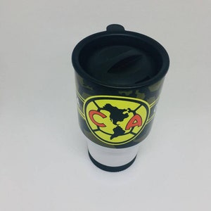 May include: A black and green travel mug with a camouflage pattern and a yellow and red logo that says "CA".
