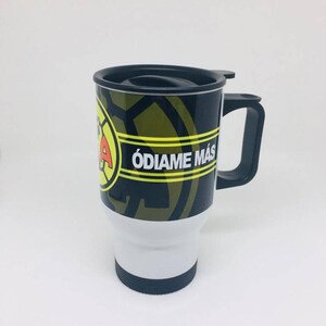 May include: A black and white travel mug with a yellow and black logo and the text "&Oacute;DIAME M&Aacute;S". The mug has a black lid and handle.