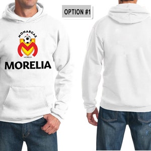 May include: White hooded sweatshirt with a black and yellow soccer team logo that says "Monarcas Morelia" on the front. The back of the sweatshirt is blank.