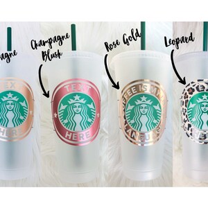Peut inclure: Quatre gobelets froids en plastique transparent avec des pailles vertes. Chaque gobelet pr&eacute;sente un design diff&eacute;rent avec le logo Starbucks. Les designs incluent : champagne, champagne blush, or rose et imprim&eacute; l&eacute;opard. Le texte sur les gobelets comprend "TEXT HERE" et "COFFEE IS MY LANGUAGE."