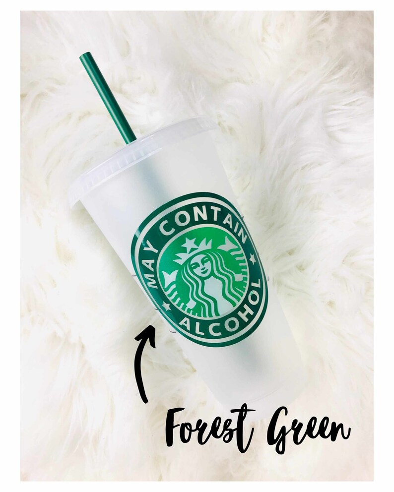 Peut inclure: Un gobelet en plastique transparent avec une paille et un couvercle verts. Le gobelet pr&eacute;sente un logo vert avec le texte "MAY CONTAIN ALCOHOL". Le texte "Forest Green" est &eacute;crit en dessous.